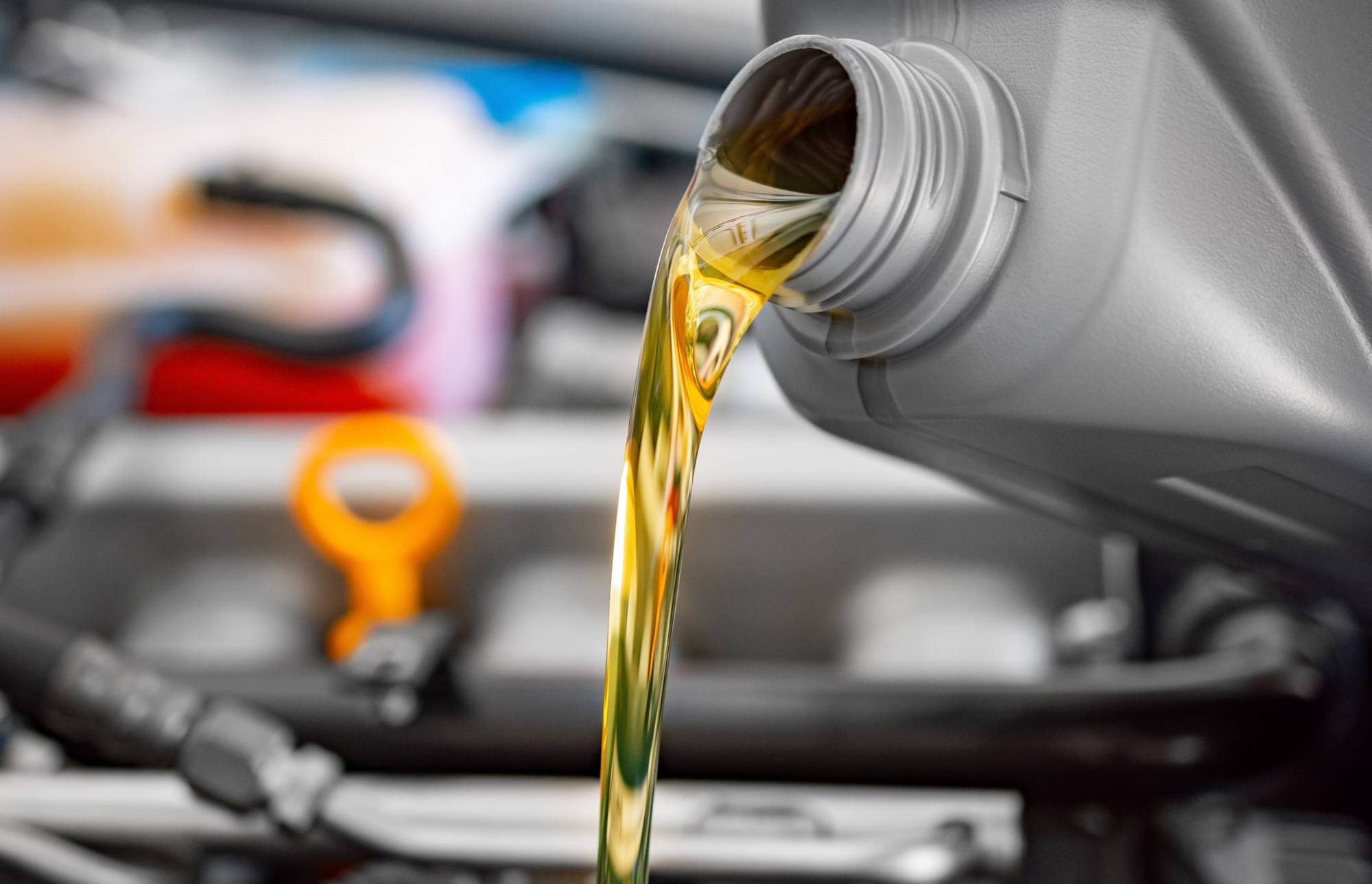 Fresh motor oil pouring into an engine