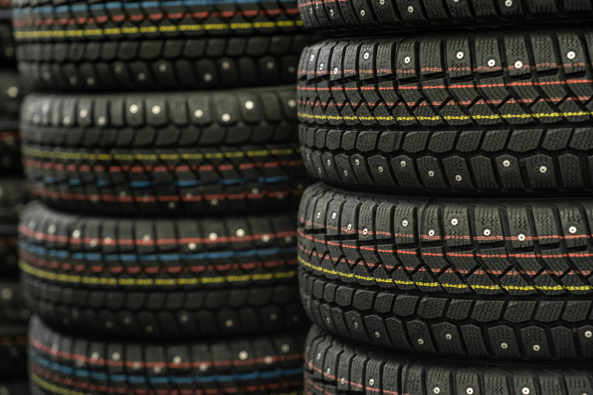 Car tires for sale in the store. Many new winter tires lie horizontally.